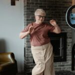 A cheerful senior woman dancing in a cozy living room, embracing the joy of movement.